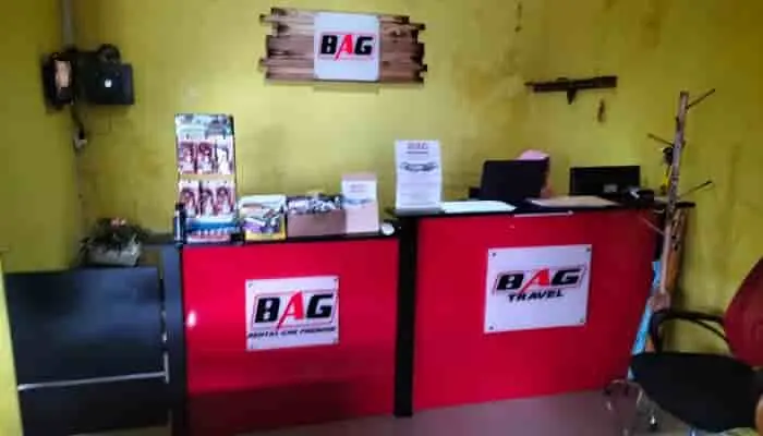 Staf admin BAG Travel siap melayani pemesanan tiket di loket kantor pusat yang bernuansa merah